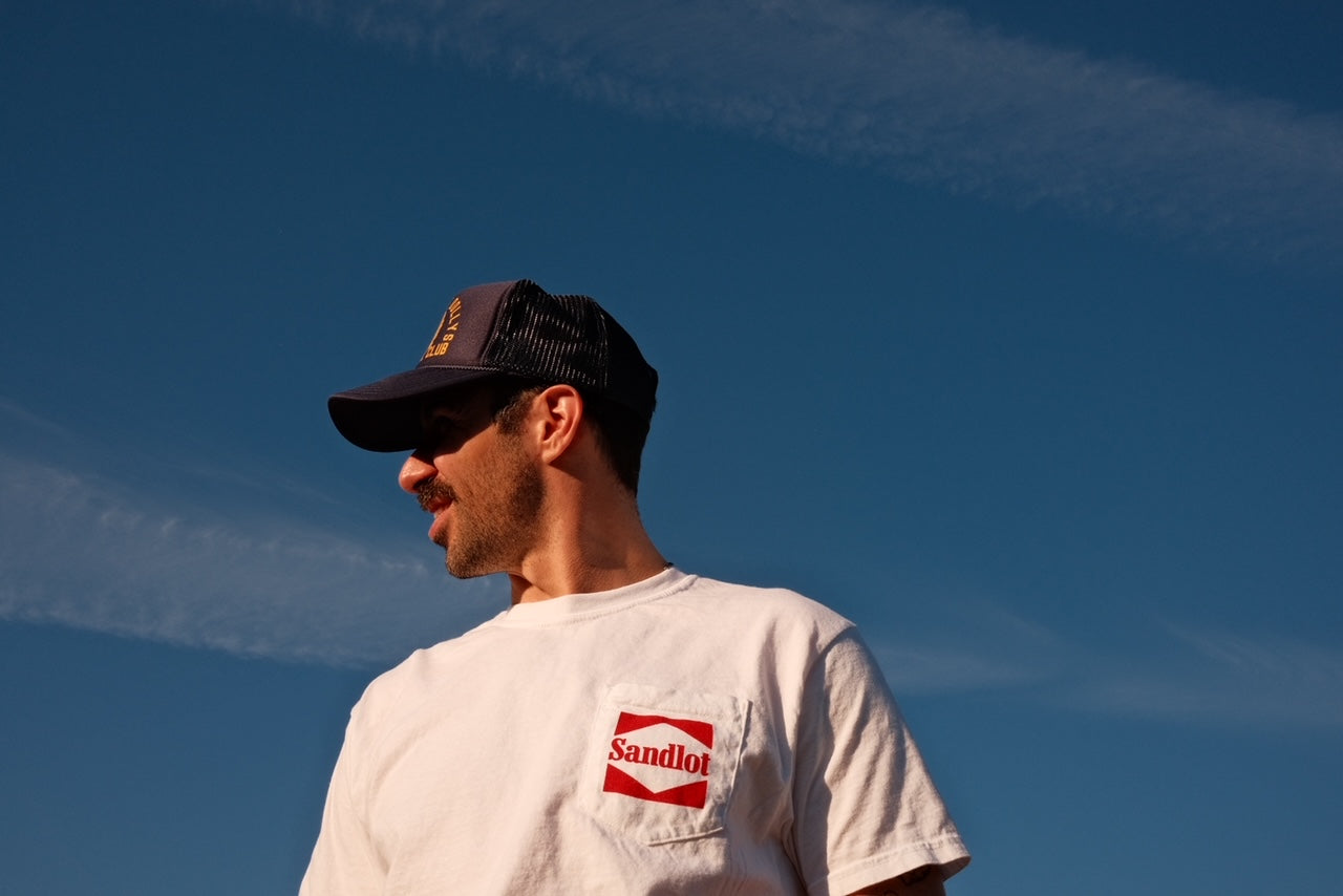 Side view of model wearing Sandlot Tee with baseball graphic on the bac
