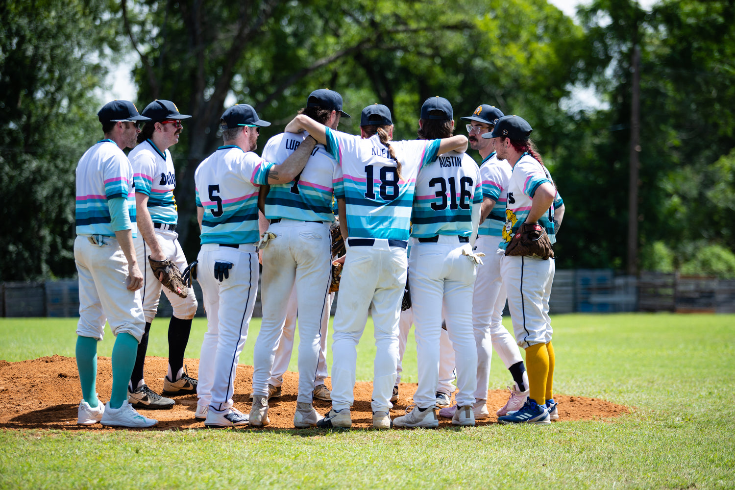 The NAshville Dolly Baseball team in a group photo on a baseball feild