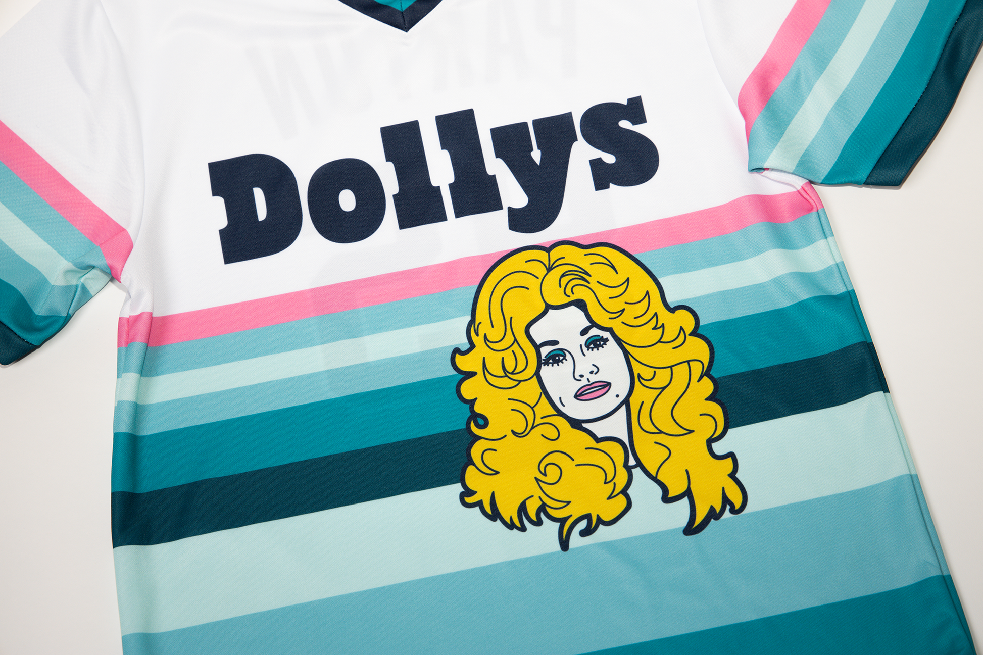 Close-up of Dolly Parton logo on the Retro 'Sunset' Jersey with striped design.
