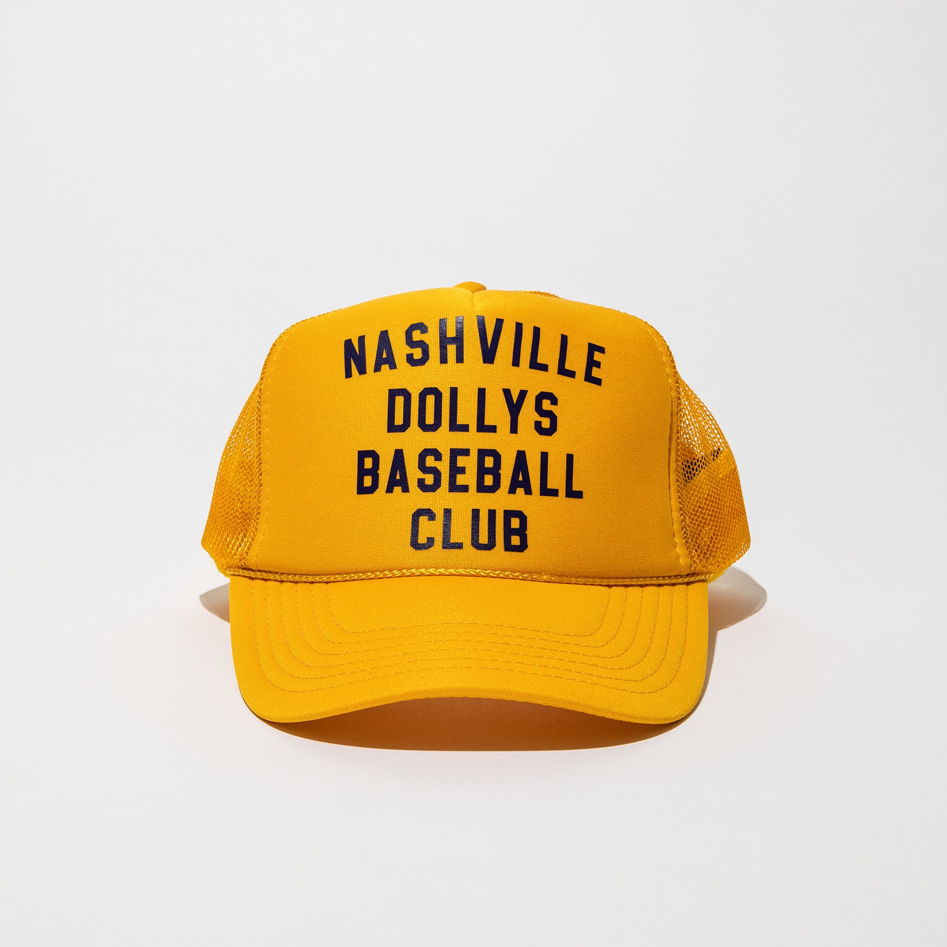 Front view of a yellow Nashville Dollys Baseball Club retro trucker hat with black text.